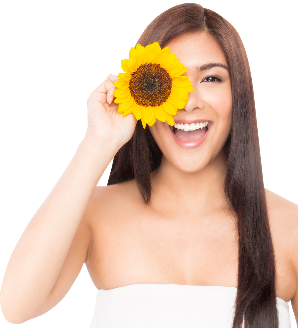 Woman holding sunflower over her right eye